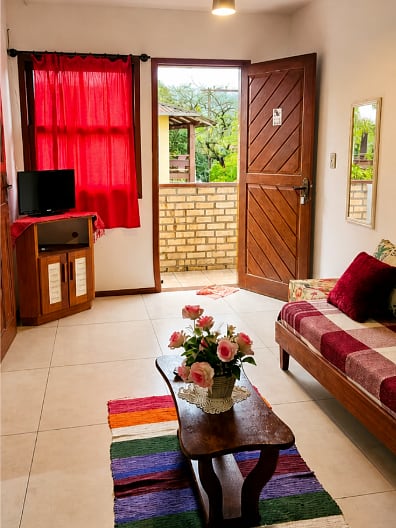Sala com vista para o jardim do apartamento Duplo do prédio principal da Pousada Capricórnio