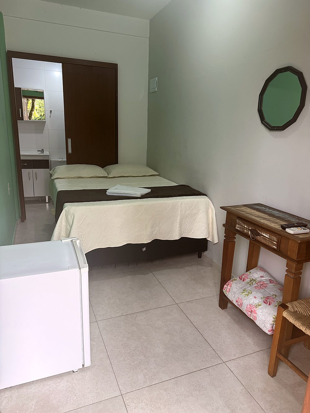 Quarto da Suíte da Pousada Capricórnio, com armário e banheiro ao fundo